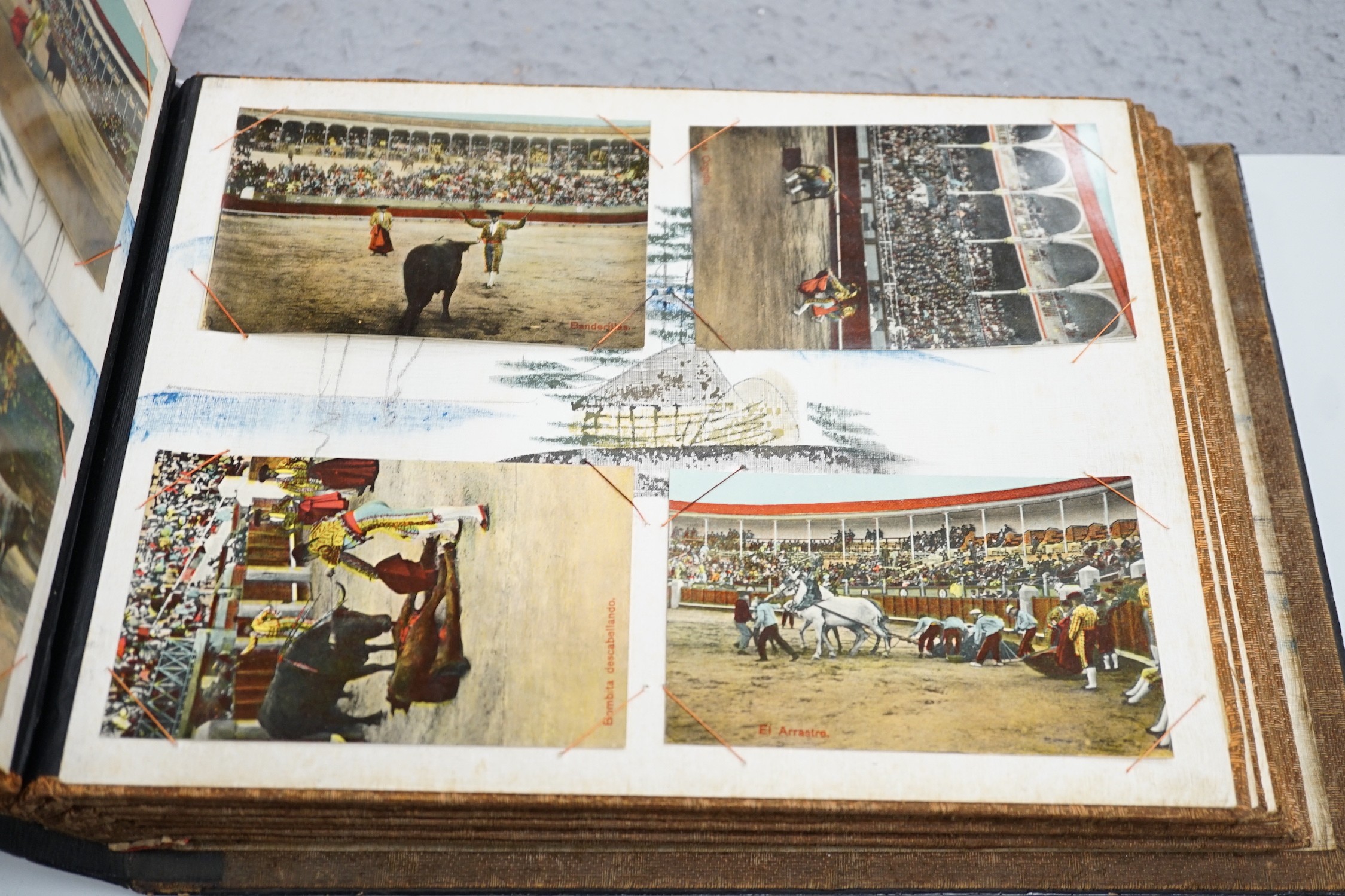 An early 20th century inlaid postcard album and contents